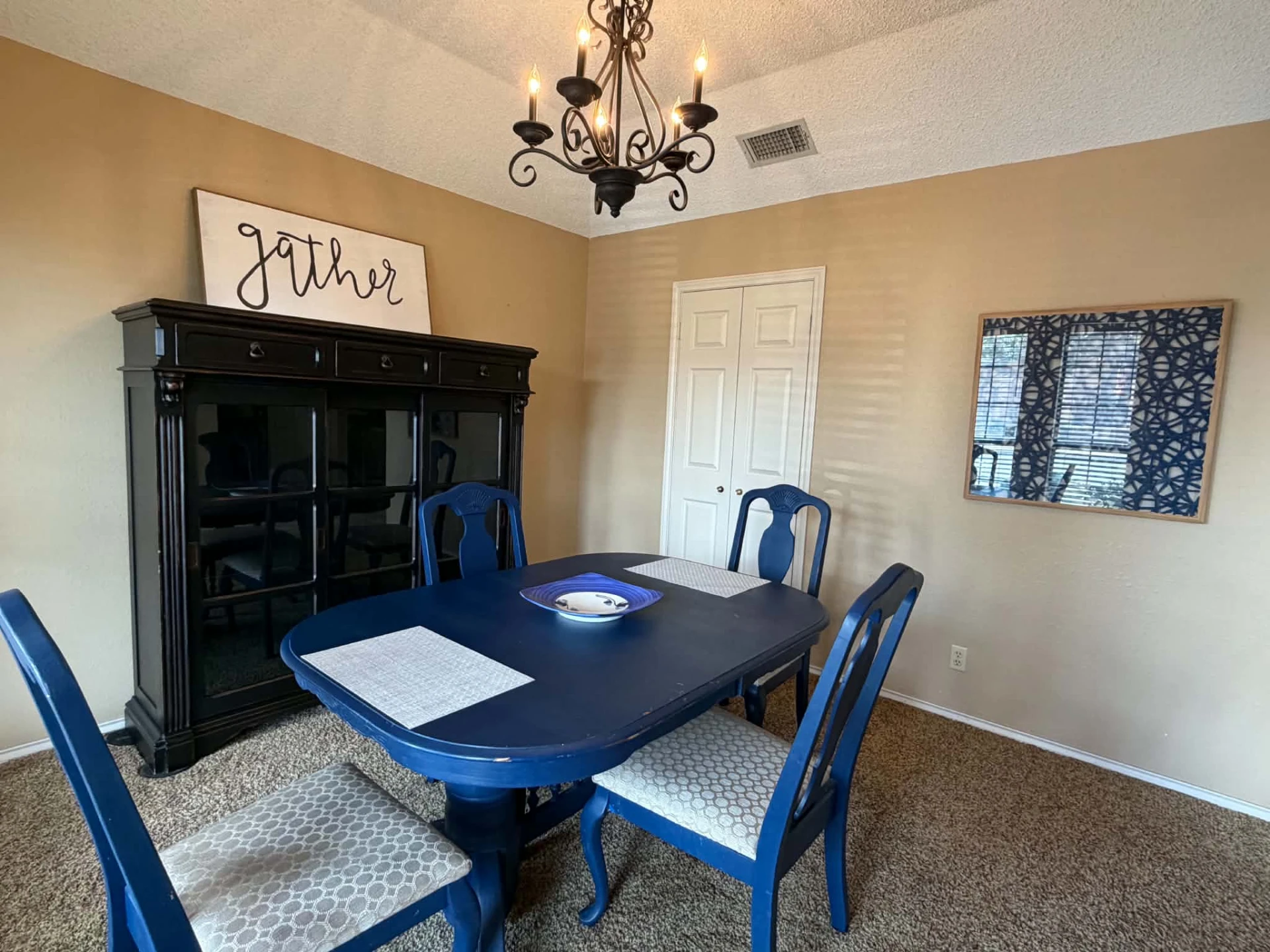 Formal dining room — china cabinet with a 'gather' sign and seating for six