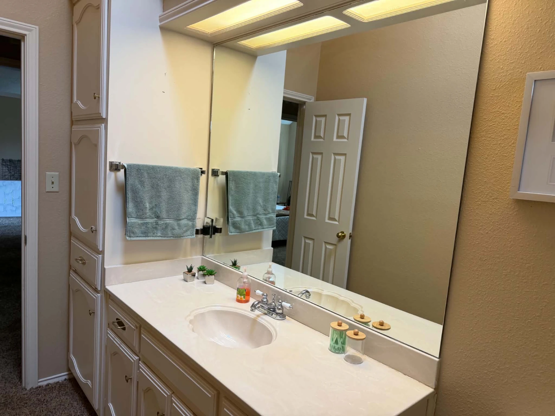 Guest bathroom — vanity with a tall built-in linen cabinet for extra storage